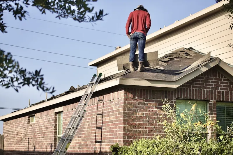 Professional roofer working on a residential roof in Monticello